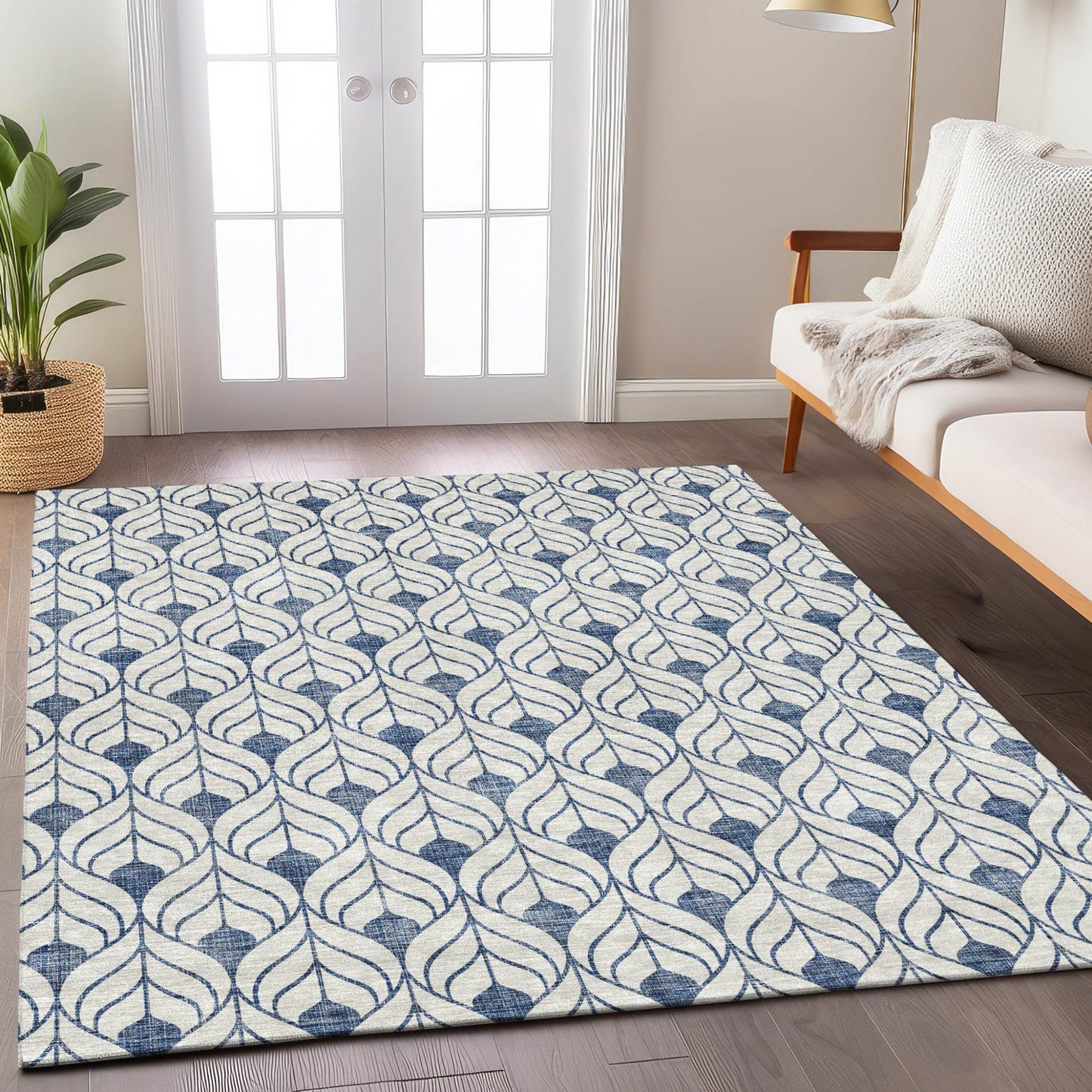 Blue and white pattern rug in front of a white couch and a double door