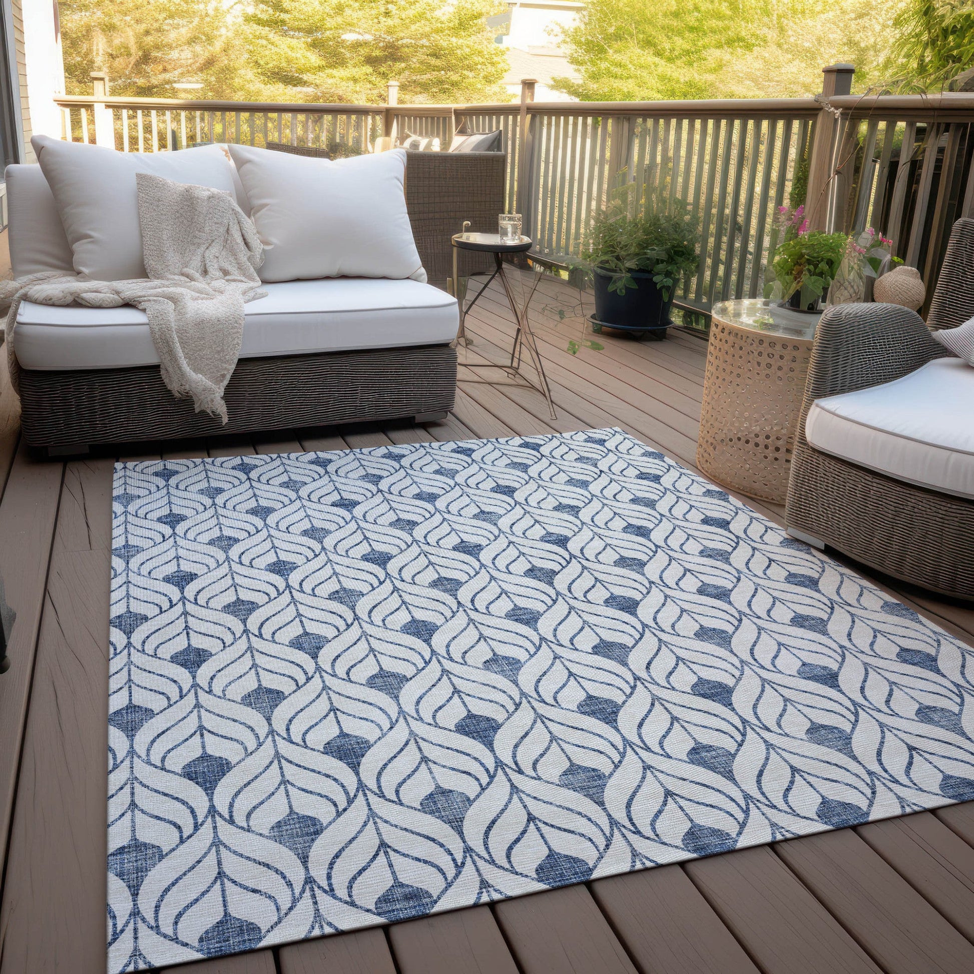 Blue and white pattern rug in front of a set of couches outside on a patio