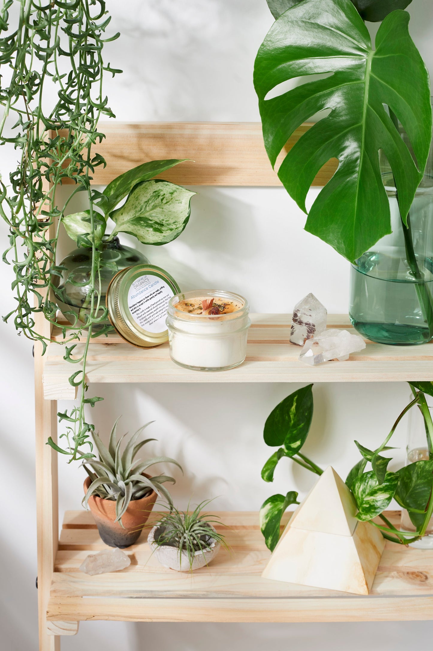 Handmade flower candle on a wooden self with plants