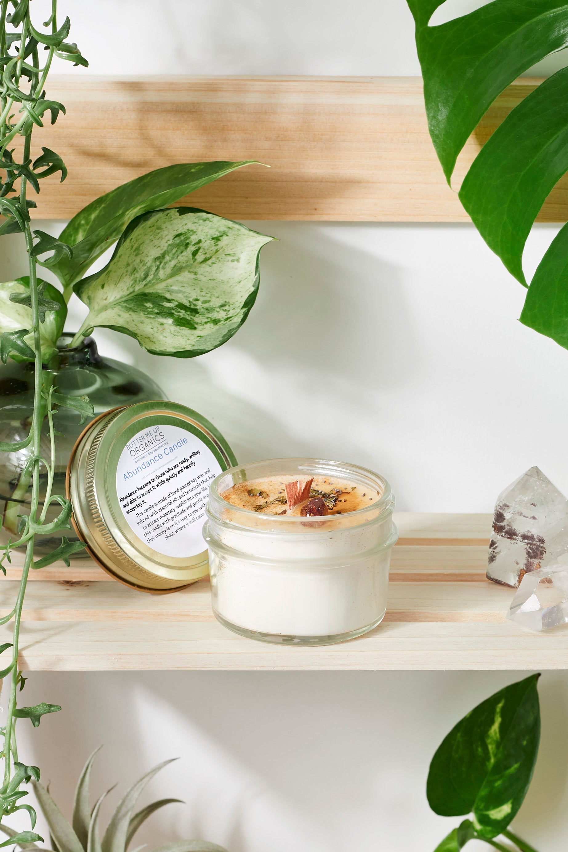 Handmade flower candle on a wooden self with plants