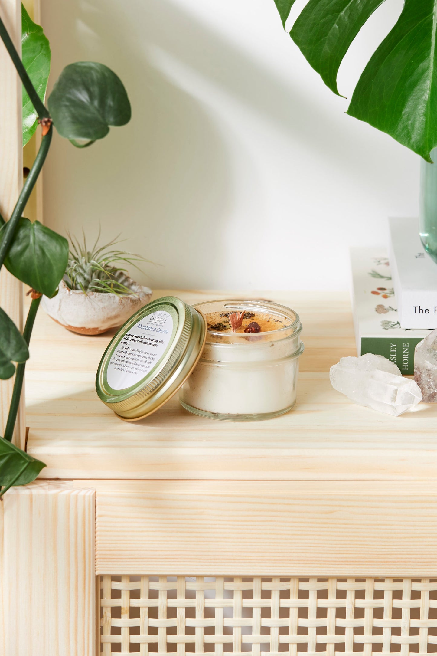 Handmade flower candle on a wooden self with plants