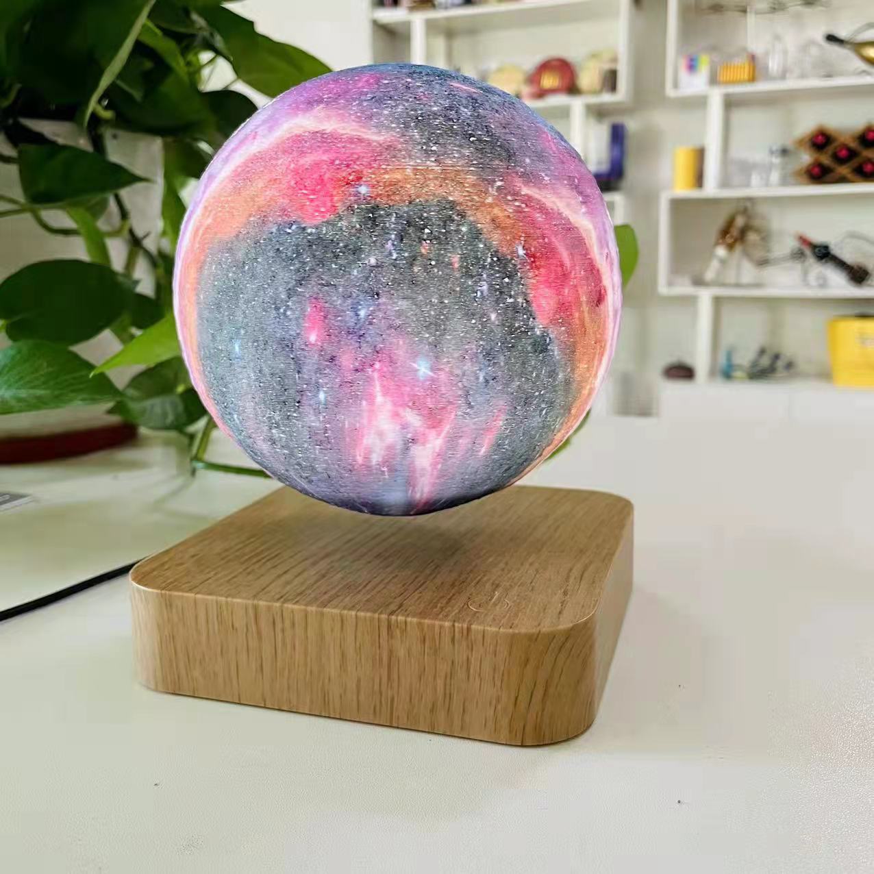 Galaxy sphere levitating on a wooden board