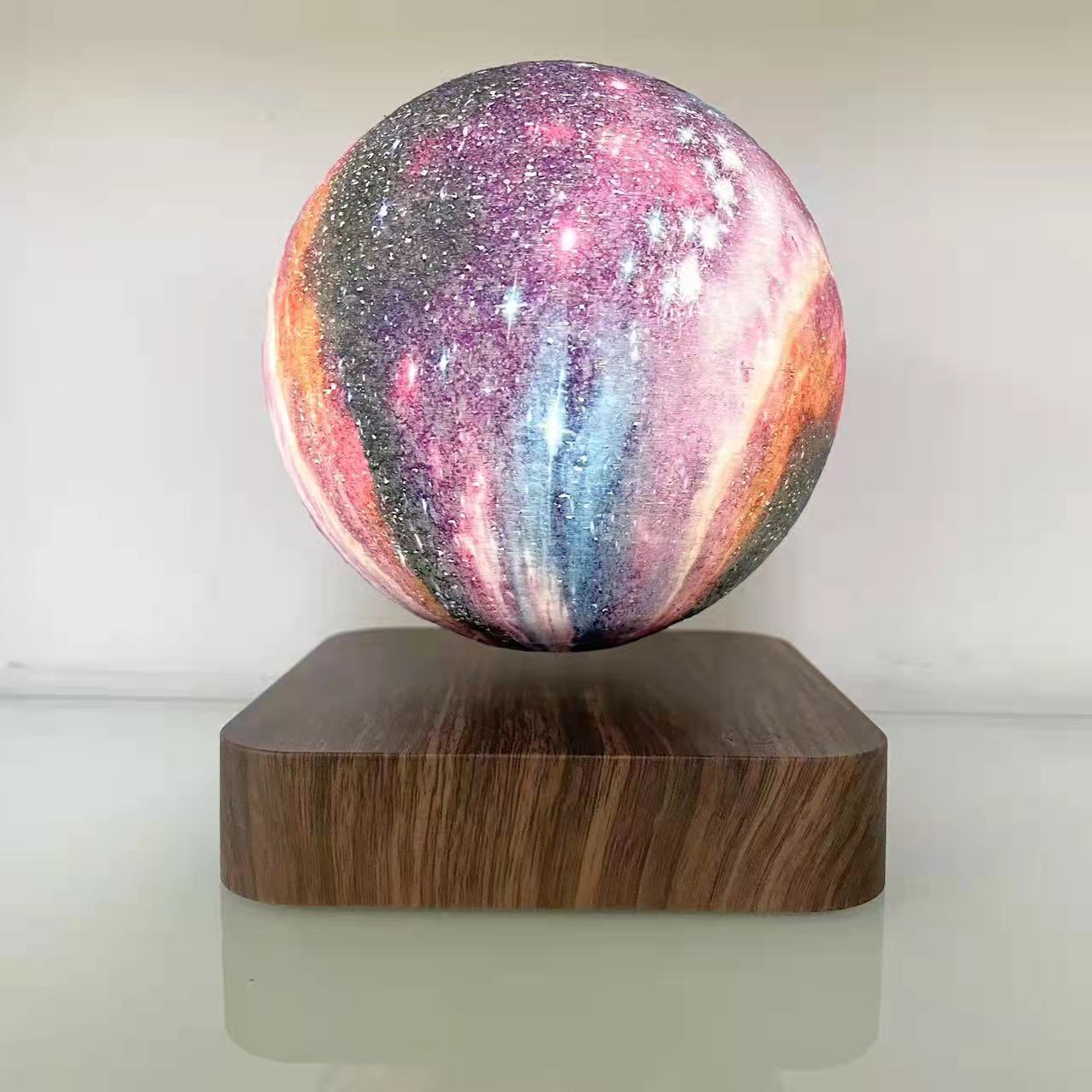 Galaxy sphere levitating on a wooden board