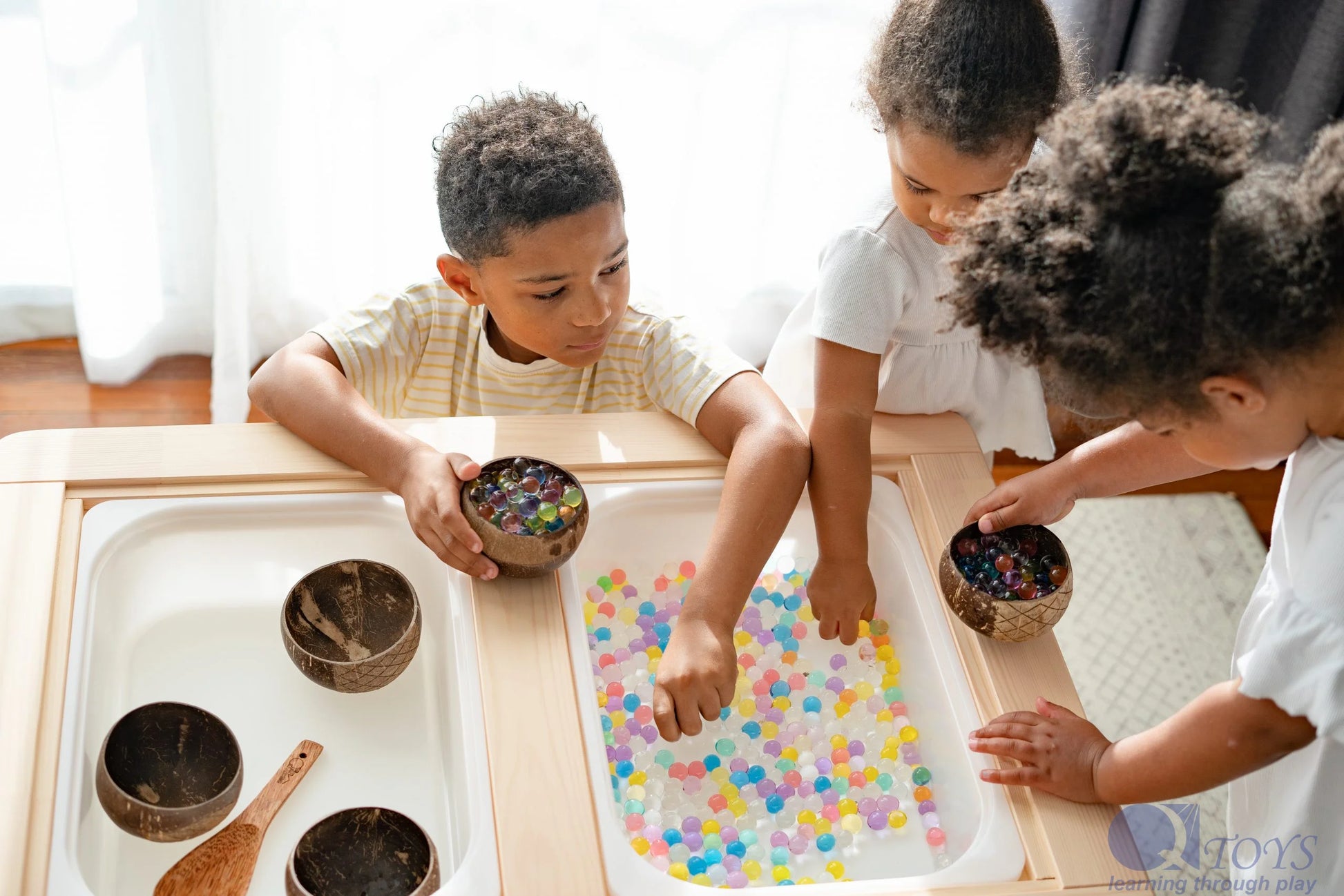 Set of wooden bowls and kids playing with beads