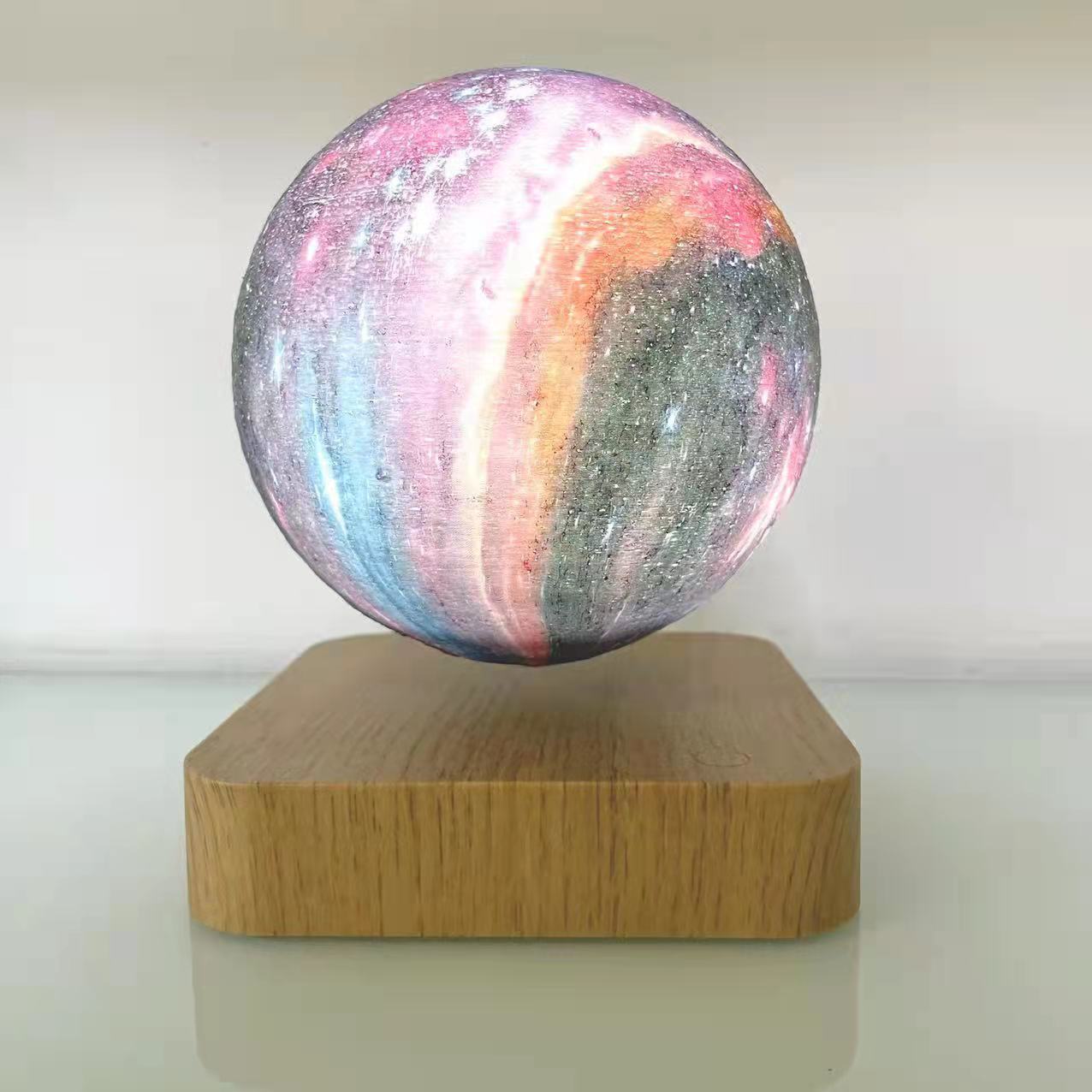 Galaxy sphere levitating on a wooden board