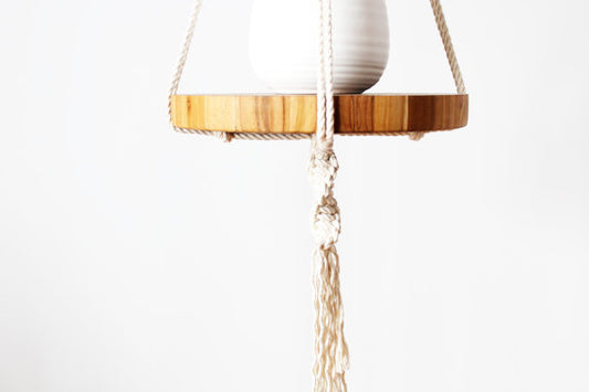 Macrame hanger plant pot with a plant and wooden base