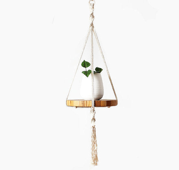 Macrame hanger plant pot with a plant and wooden base