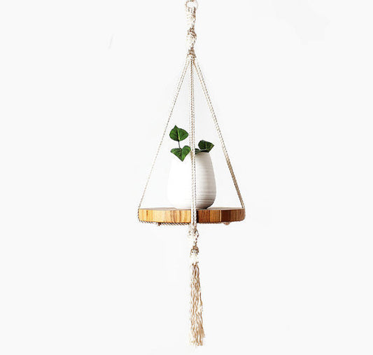 Macrame hanger plant pot with a plant and wooden base