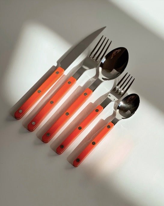Orange silver cutlery on a table