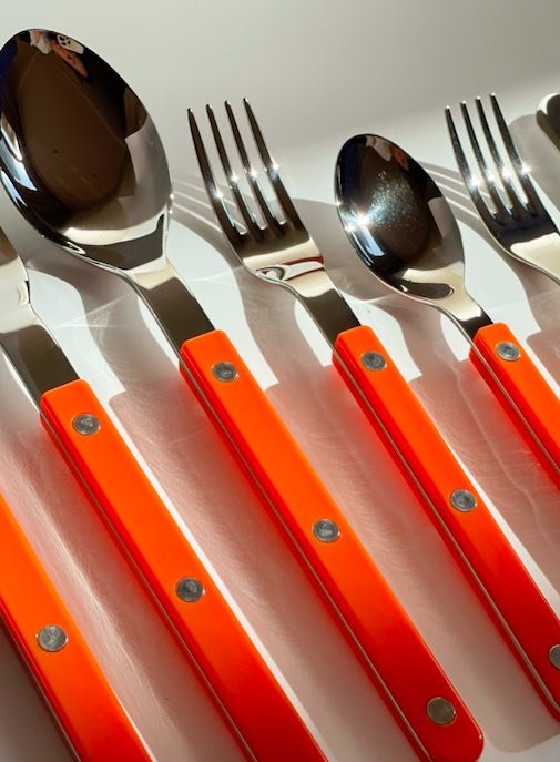 Orange silver cutlery on a table